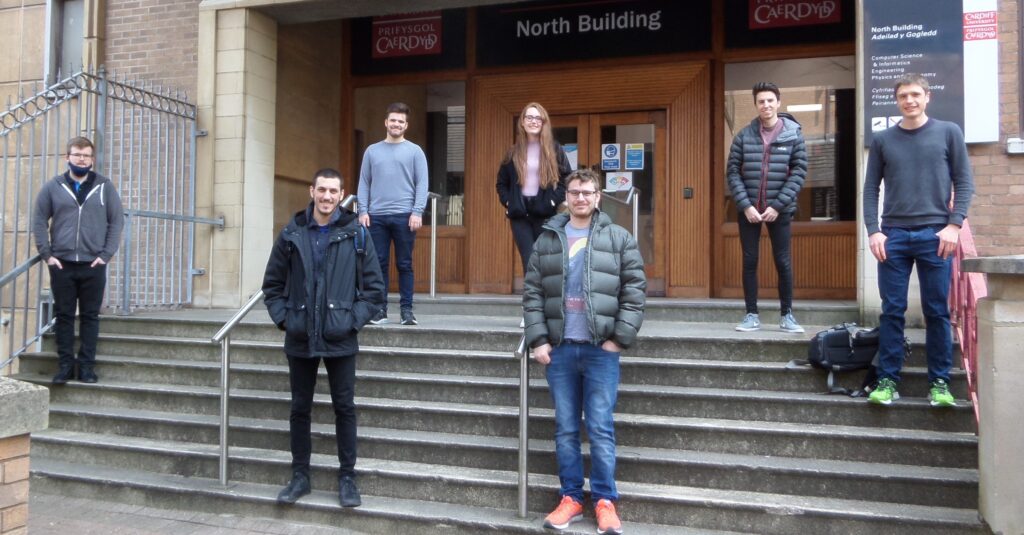 seven of the 14 students in Cohort 2 outside North Building socially distanced